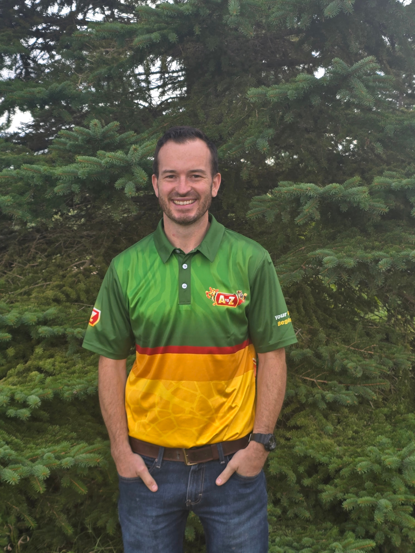 Adam, owner of A to Z, smiling in his branded A to Z shirt